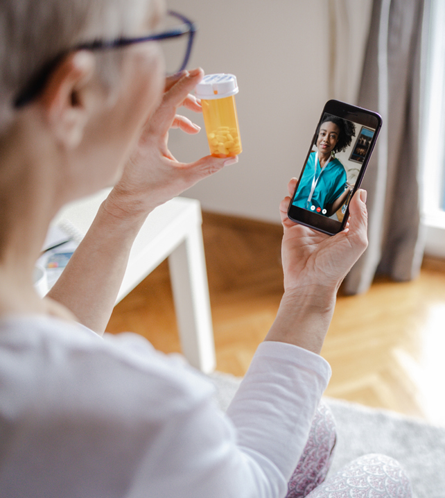 patient shwing container of pills to doctor during a telehealth appointment