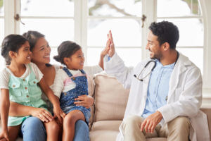 A smiling girl high-fives her family medicine provider after receiving positive test results.