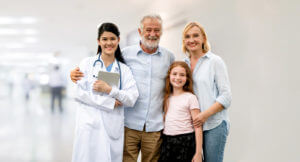 A family medicine provider with happy family of mother, father and daughter at the hospital..