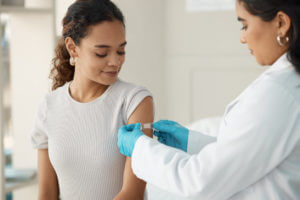 doctor applying a band-aid after injecting her patient during a consultation in the clinic